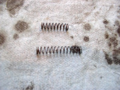 The right choke plunger spring (top) was apparently replaced with an incorrect one. A good used correct spring (bottom) was installed. With the incorrect spring, the 